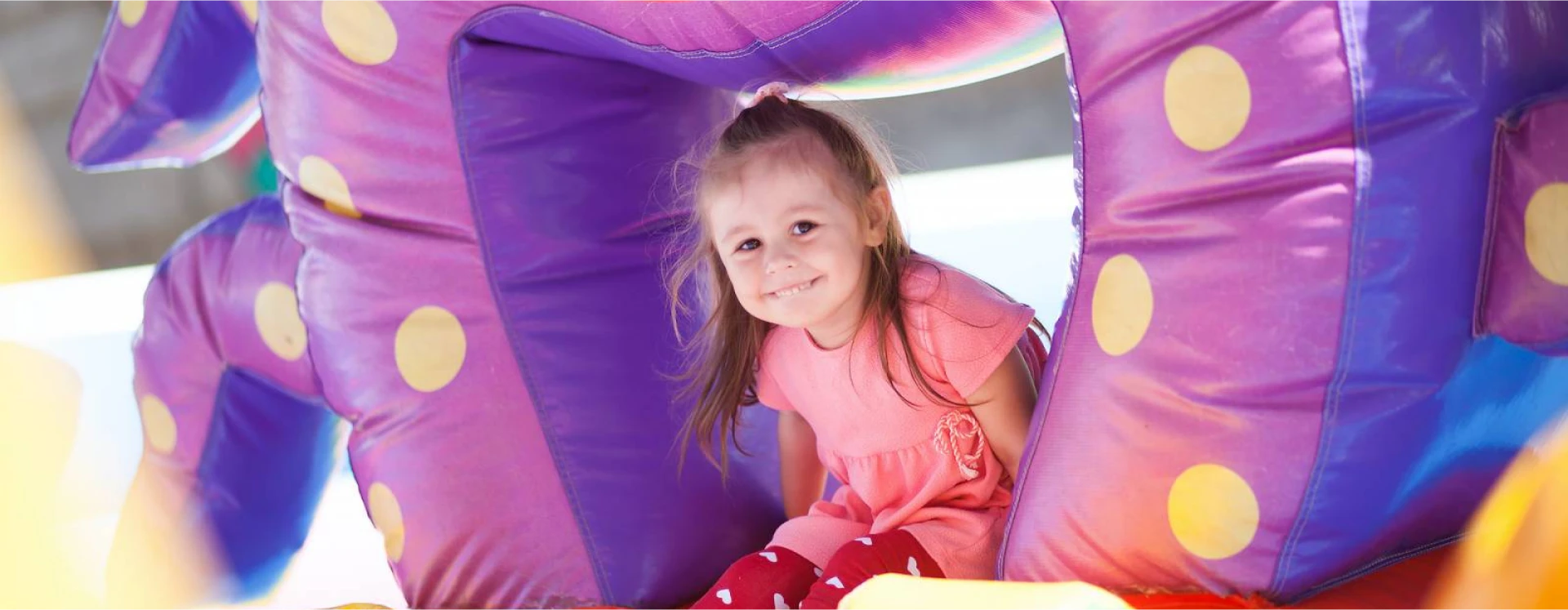 White bounce house rental at an outdoor celebration in soft light