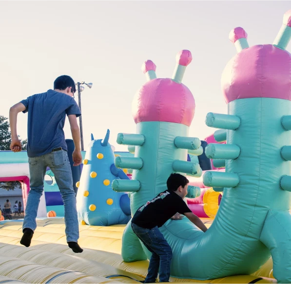 Kids jumping in a birthday bounce house rental at a party