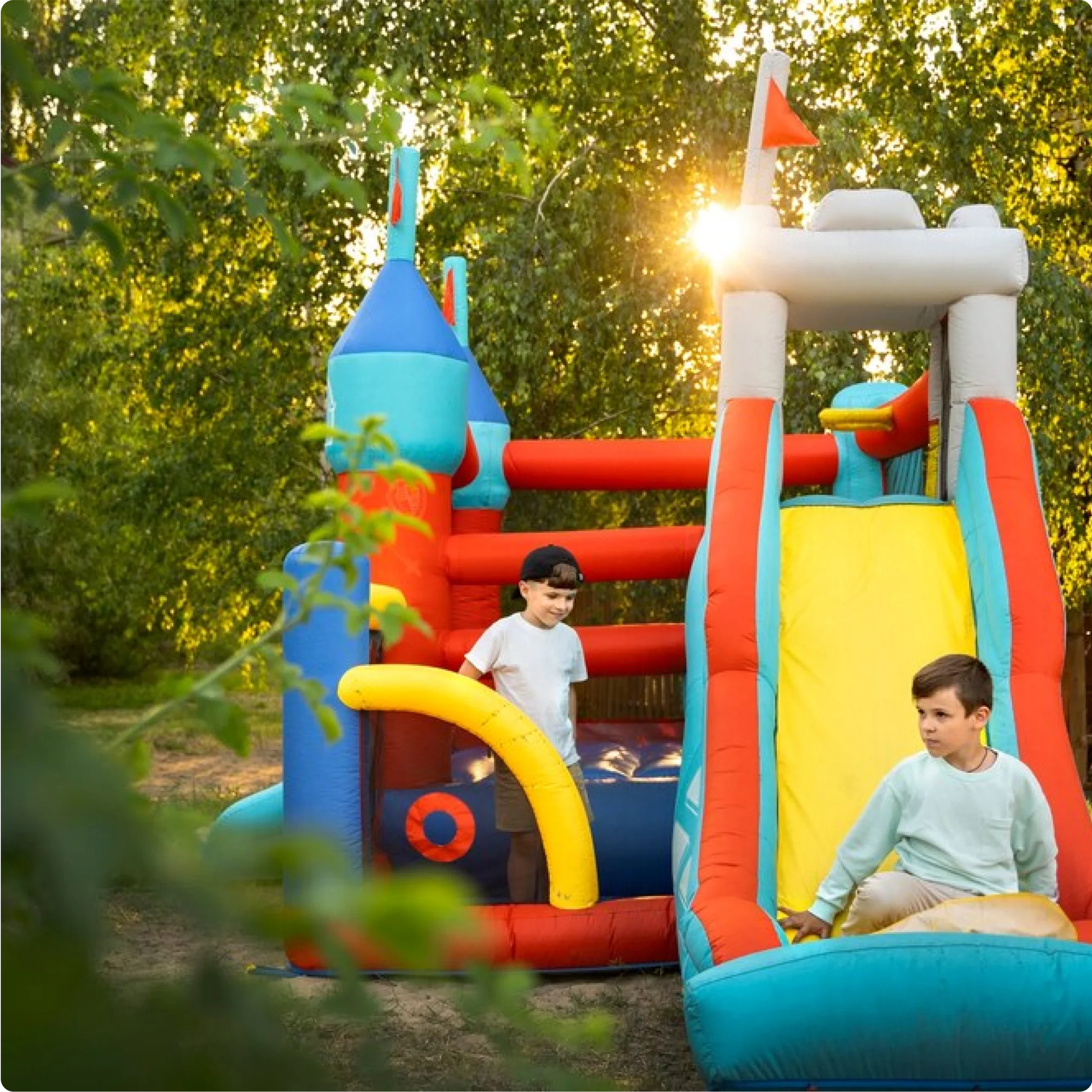 Kids sliding down an inflatable water slide rental at a party